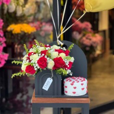 Wooden box filled with fresh flowers paired with a delicious cake 